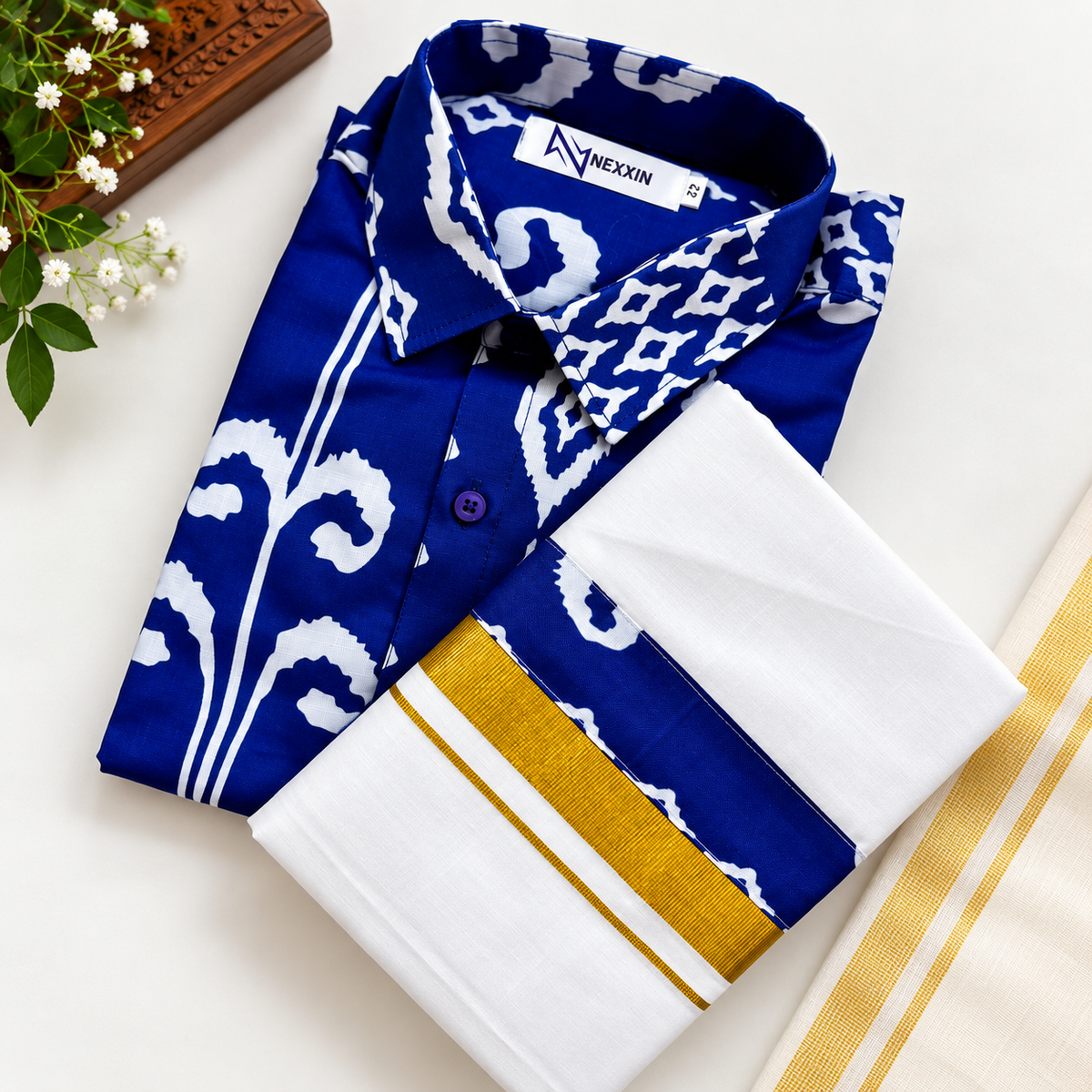 Navy blue printed shirt with white cotton dhoti and gold kasavu border. Traditional Kerala Onam menswear.